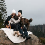 Inniges Kuscheln von Mann und Frau mit ihren beiden Tierschutzhunden am Oderteich im Harz - ein herzliches Familienbild voller Liebe und Verbundenheit inmitten der Natur.