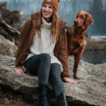 Farblich abgestimmter Irish Setter und Frau genießen den Moment im Panorama des Oderteichs im Harz und blicken in die Ferne