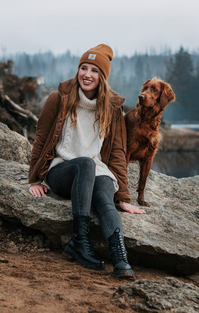 Farblich abgestimmter Irish Setter und Frau genießen den Moment im Panorama des Oderteichs im Harz und blicken in die Ferne